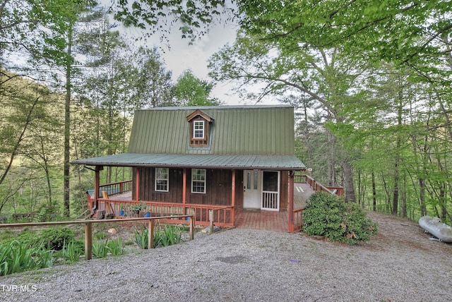 rustic home featuring a porch, board and batten siding, and metal roof