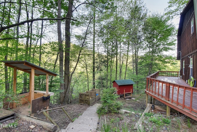view of yard with a storage shed, an outdoor structure, and a wooden deck