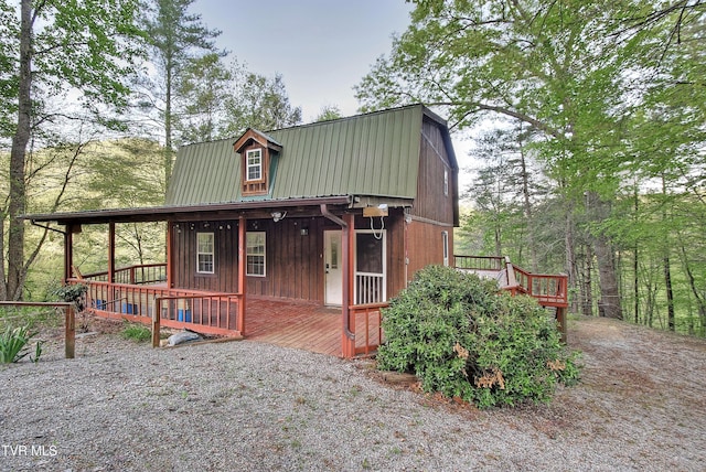 rustic home with a porch, a gambrel roof, and metal roof