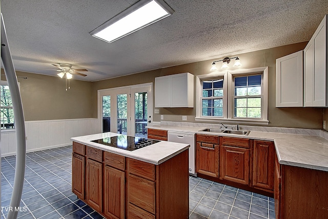 kitchen with white dishwasher, black electric cooktop, a textured ceiling, a sink, and light tile patterned floors