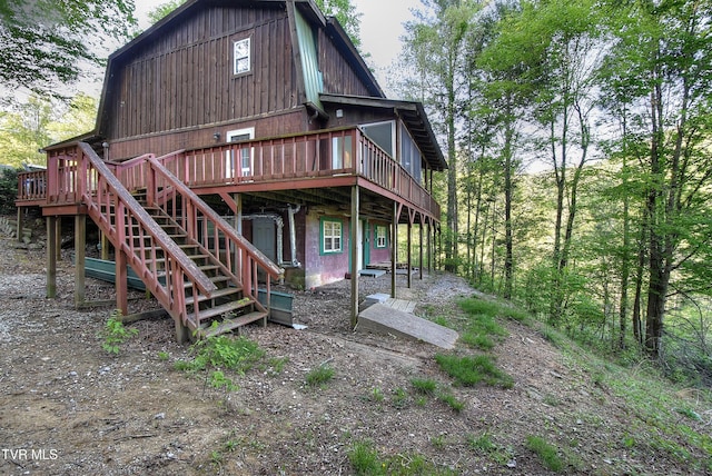 back of property with a wooden deck and stairway