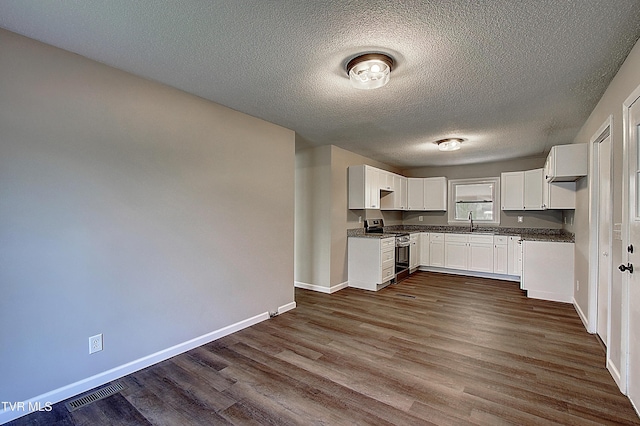 kitchen with stainless steel stove, baseboards, dark countertops, dark wood-type flooring, and a textured ceiling