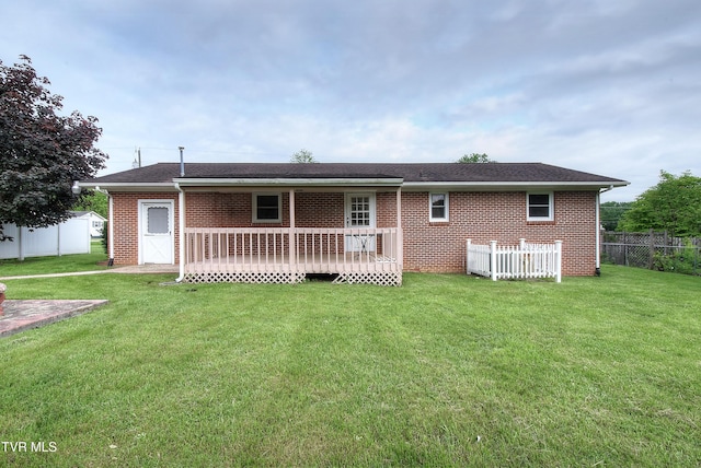 back of property with brick siding, a deck, and a shingled roof