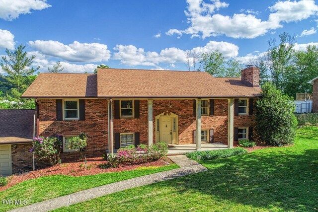 2653 Suffolk St, Kingsport, TN 37660 - split foyer home with a chimney, brick siding, a front lawn, and roof with shingles