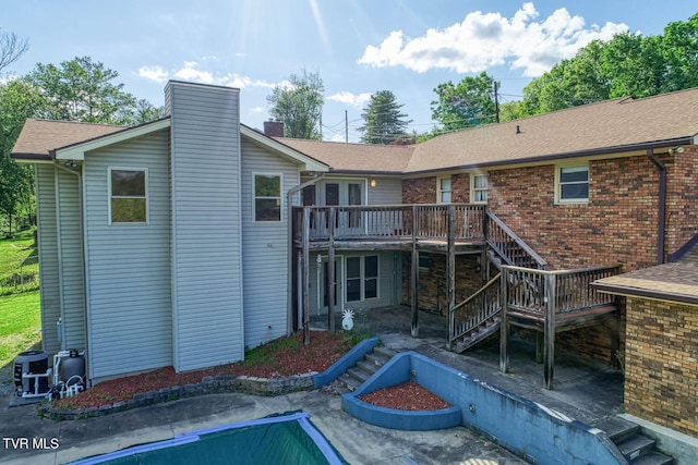 2653 Suffolk St, Kingsport, TN 37660 - rear view of property with stairs, a deck, a chimney, an empty pool, and brick siding