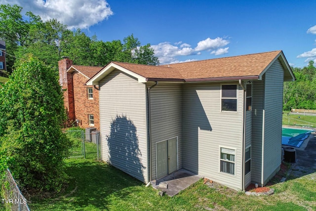 2653 Suffolk St, Kingsport, TN 37660 - rear view of property with central AC unit, a shingled roof, and a chimney