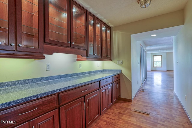 2653 Suffolk St, Kingsport, TN 37660 - kitchen with light wood-style flooring, glass insert cabinets, dark countertops, baseboards, and recessed lighting