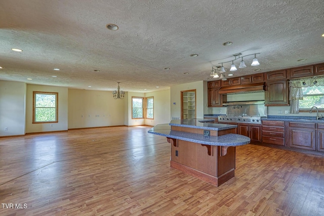 2653 Suffolk St, Kingsport, TN 37660 - kitchen featuring light wood-style flooring, a kitchen bar, open floor plan, a textured ceiling, and a chandelier