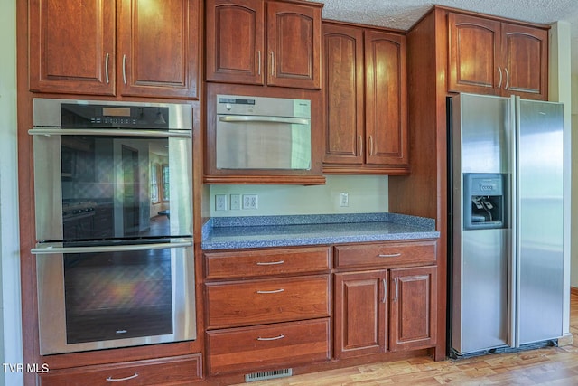 2653 Suffolk St, Kingsport, TN 37660 - kitchen with stainless steel appliances, brown cabinets, and light wood-style floors