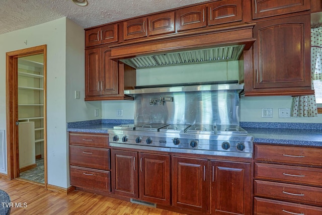 2653 Suffolk St, Kingsport, TN 37660 - kitchen with light wood finished floors, dark countertops, stainless steel gas cooktop, premium range hood, and a textured ceiling