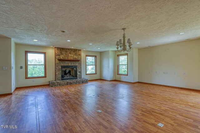 2653 Suffolk St, Kingsport, TN 37660 - unfurnished living room with wood finished floors, a chandelier, baseboards, a textured ceiling, and recessed lighting