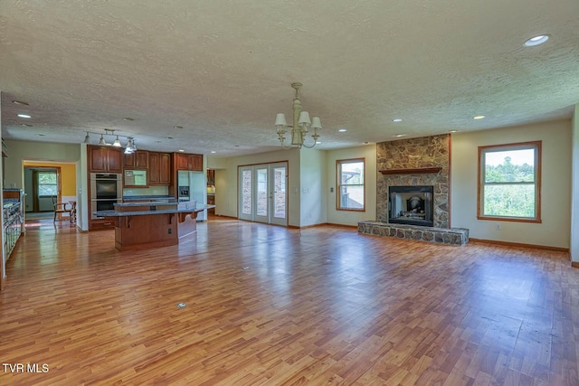 2653 Suffolk St, Kingsport, TN 37660 - unfurnished living room with a chandelier, a textured ceiling, light wood finished floors, baseboards, and recessed lighting