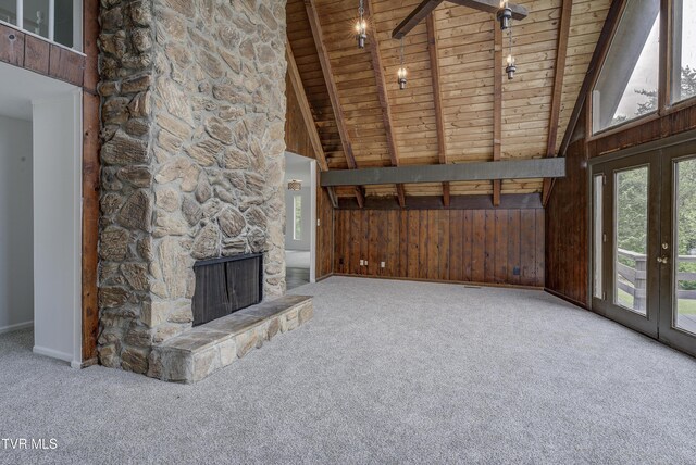 unfurnished living room featuring wood ceiling, carpet flooring, wood walls, baseboards, and french doors