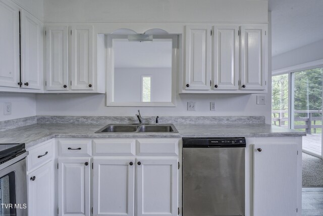 kitchen featuring stainless steel appliances, a sink, and white cabinetry