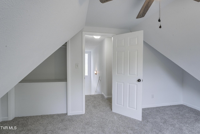 additional living space featuring carpet, lofted ceiling, and a ceiling fan