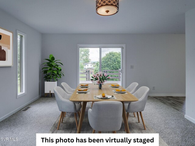 carpeted dining area featuring baseboards
