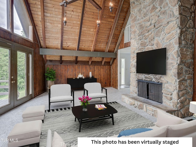 carpeted living room with wooden ceiling, wooden walls, beam ceiling, high vaulted ceiling, and a fireplace