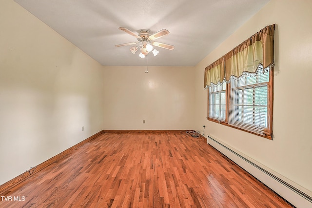 spare room with baseboards, ceiling fan, baseboard heating, and light wood-style floors