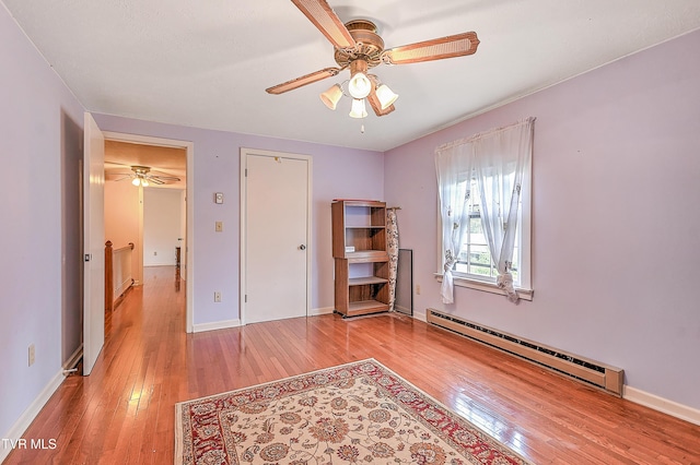 bedroom with ceiling fan, baseboards, a baseboard radiator, and hardwood / wood-style floors