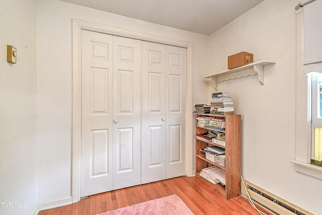 interior space featuring baseboard heating, light wood-style flooring, and a closet