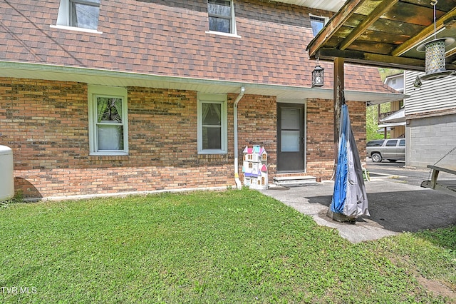 3851 Helen Henderson Hwy, Davenport, VA 24239 - view of exterior entry featuring a lawn, a shingled roof, and brick siding