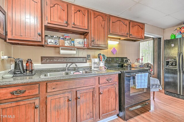 3851 Helen Henderson Hwy, Davenport, VA 24239 - kitchen featuring a sink, light wood-style flooring, brown cabinets, and black appliances