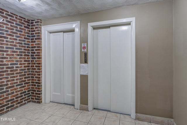 200 E Main St Unit 201, Johnson City, TN 37604 - basement featuring brick wall, light tile patterned flooring, and elevator