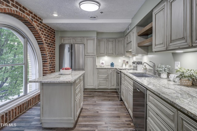 200 E Main St Unit 201, Johnson City, TN 37604 - kitchen with stainless steel appliances, a textured ceiling, open shelves, brick wall, and dark wood-type flooring