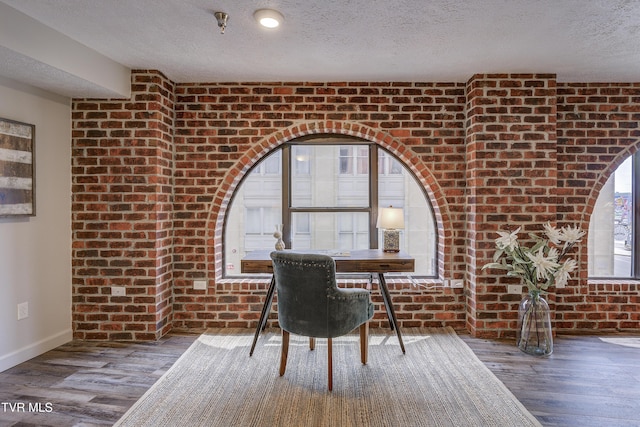 200 E Main St Unit 201, Johnson City, TN 37604 - dining area featuring brick wall, a textured ceiling, and wood finished floors