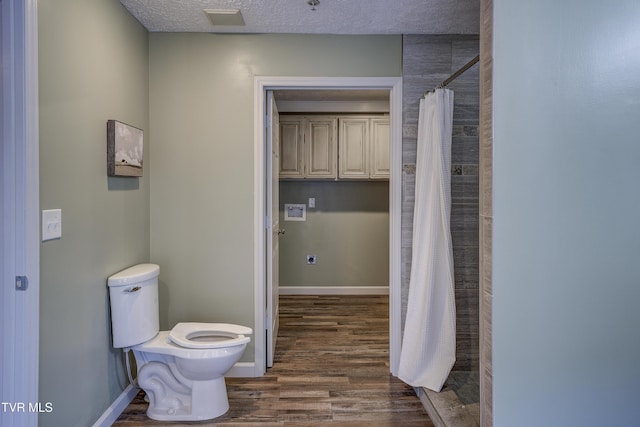 200 E Main St Unit 201, Johnson City, TN 37604 - bathroom featuring wood finished floors, tiled shower, and a textured ceiling
