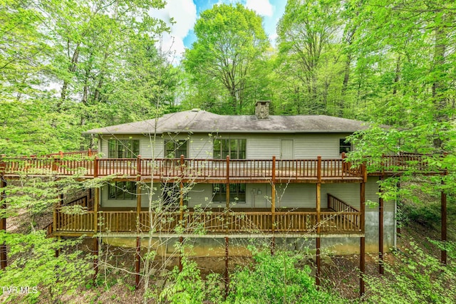 rear view of property featuring a deck and a chimney
