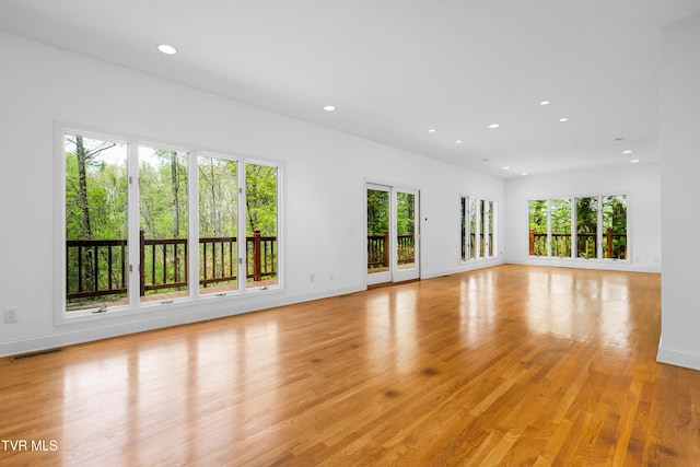 unfurnished living room featuring plenty of natural light, light wood finished floors, recessed lighting, and visible vents