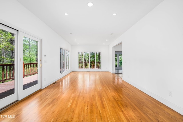 empty room with light wood-type flooring, recessed lighting, and baseboards
