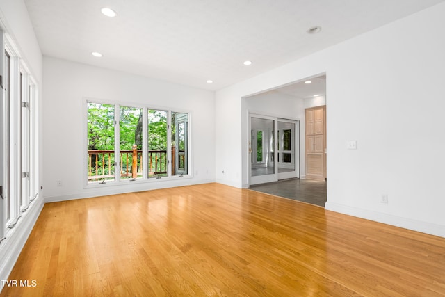 unfurnished room with recessed lighting, baseboards, and wood finished floors