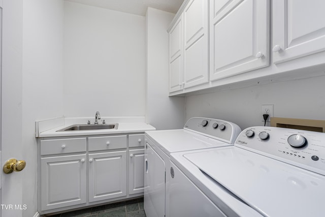 washroom with cabinet space, a sink, and washer and dryer