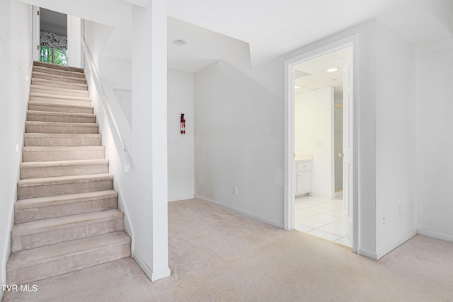 staircase with baseboards and carpet flooring