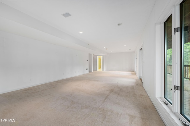 spare room featuring baseboards, plenty of natural light, recessed lighting, and light colored carpet