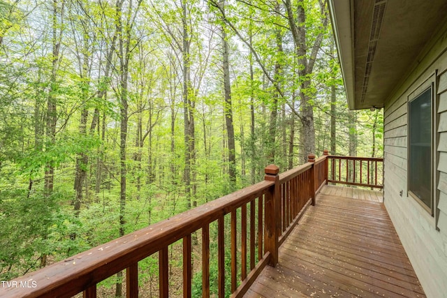 wooden terrace with a wooded view