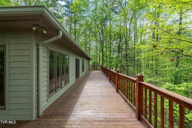 wooden terrace with a wooded view