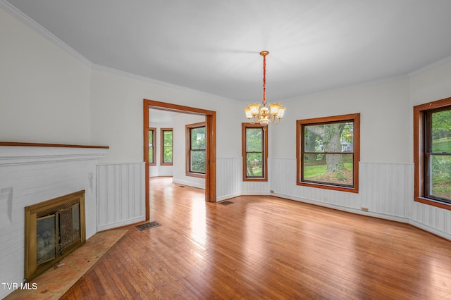 243 NW Mason Pl, Abingdon, VA 24210 - unfurnished living room with visible vents, an inviting chandelier, a brick fireplace, a wainscoted wall, and hardwood / wood-style flooring