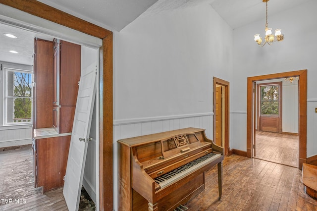 243 NW Mason Pl, Abingdon, VA 24210 - hall featuring wood-type flooring, wainscoting, a healthy amount of sunlight, and an inviting chandelier