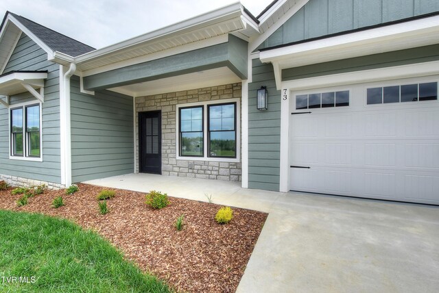doorway to property featuring board and batten siding and stone siding