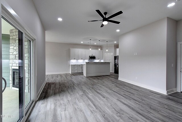 unfurnished living room with recessed lighting, baseboards, ceiling fan, and dark wood-style floors