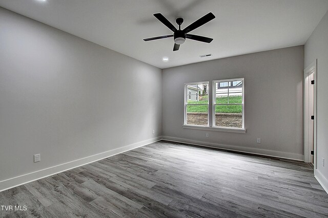 unfurnished room featuring visible vents, baseboards, and wood finished floors