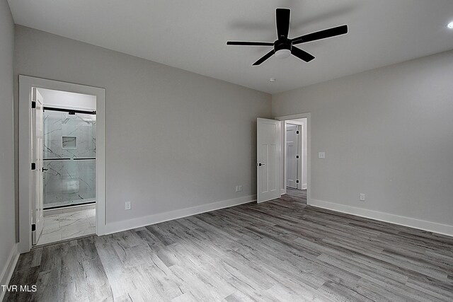 empty room featuring ceiling fan, baseboards, and wood finished floors