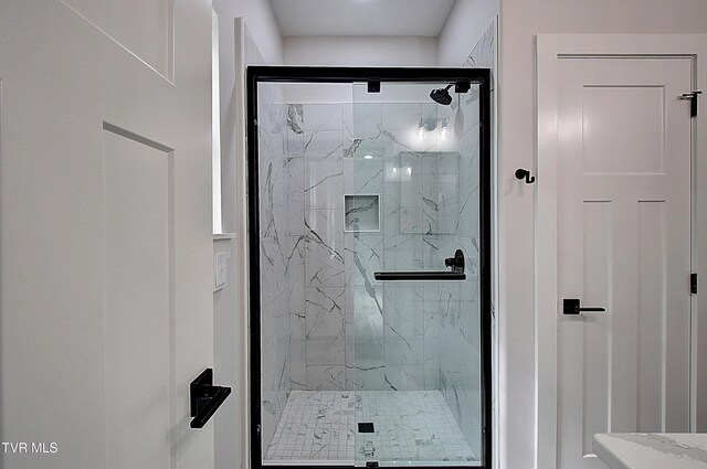 full bathroom featuring a marble finish shower