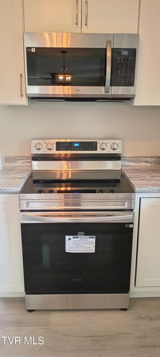 2160 Whirlwind Rd, Greeneville, TN 37743 - room details with stainless steel appliances, light countertops, white cabinets, and wood finished floors