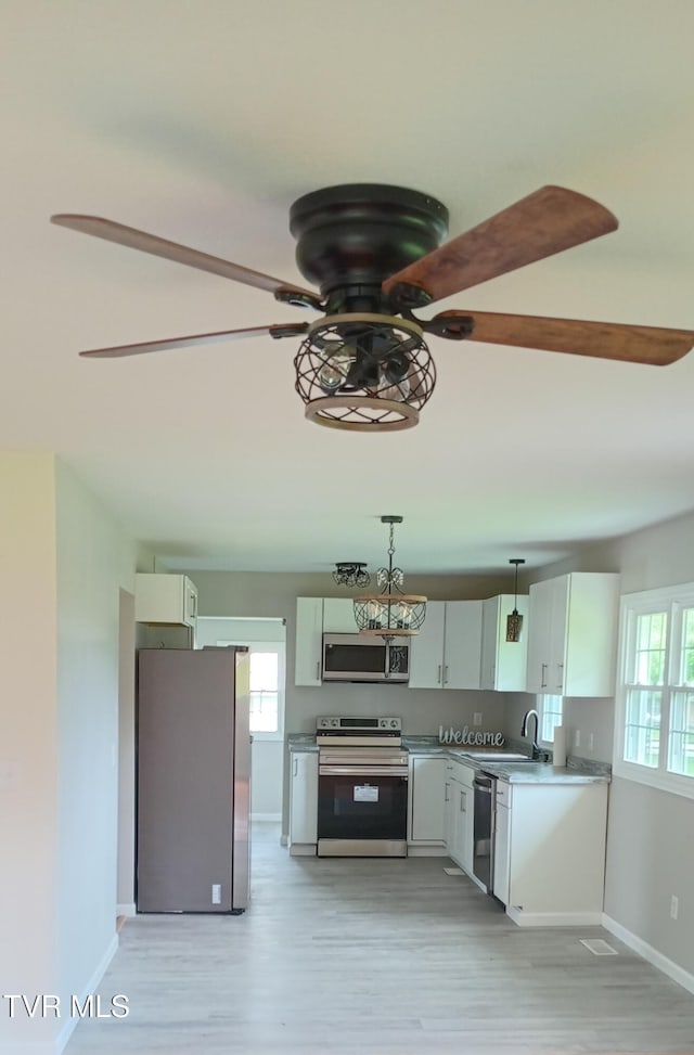2160 Whirlwind Rd, Greeneville, TN 37743 - kitchen with light wood-type flooring, stainless steel appliances, baseboards, and a ceiling fan
