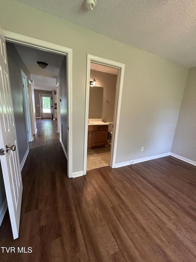 608 Walnut St, Elizabethton, TN 37643 - hallway featuring dark wood finished floors, baseboards, and a textured ceiling