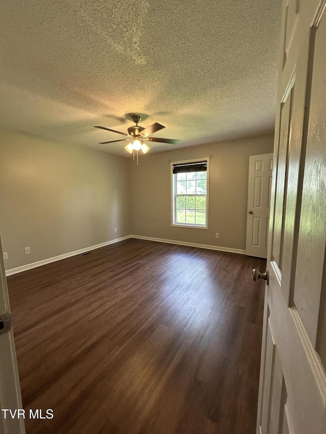 608 Walnut St, Elizabethton, TN 37643 - spare room with dark wood finished floors, a textured ceiling, a ceiling fan, and baseboards